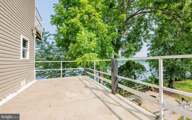 a view of a deck with a two chairs next to a yard