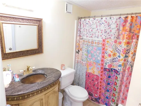 a bathroom with a granite countertop sink a toilet and a mirror