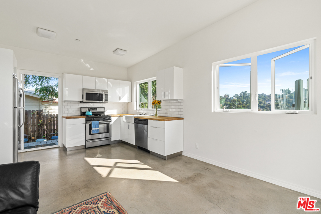 2275 Ewing Street Los Angeles, CA 90039 - Photo 4 of 19 a kitchen with stainless steel appliances kitchen island granite countertop a stove a sink and a refrigerator