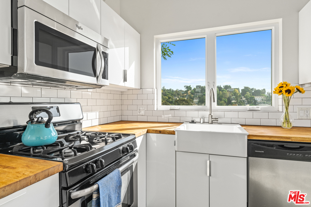2275 Ewing Street Los Angeles, CA 90039 - Photo 9 of 19 a kitchen with stainless steel appliances granite countertop a sink stove and microwave