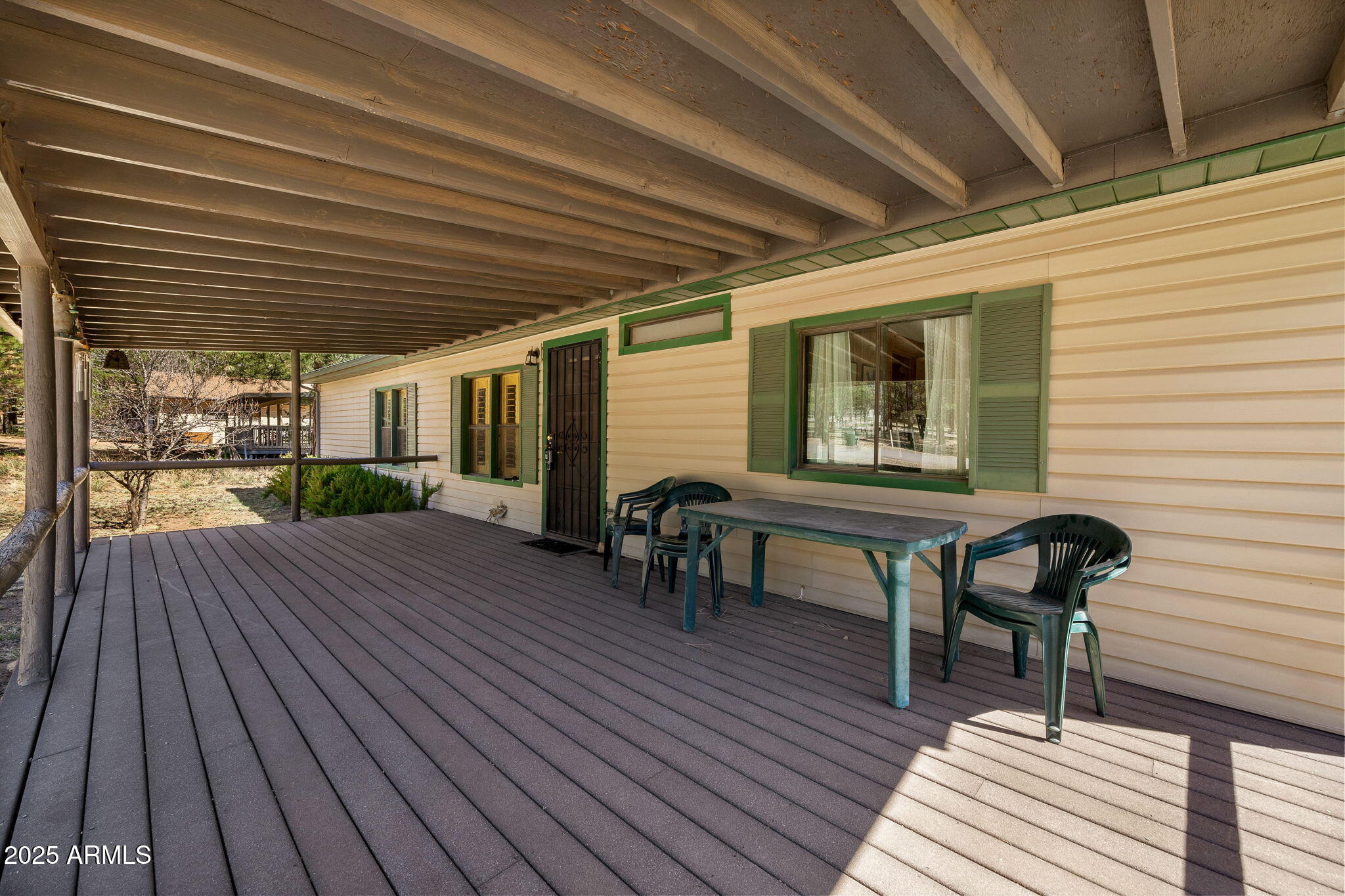 2841 Pine Rim Road Overgaard, AZ 85933 - Photo 6 of 36 a view of a patio with table and chairs with wooden floor and fence