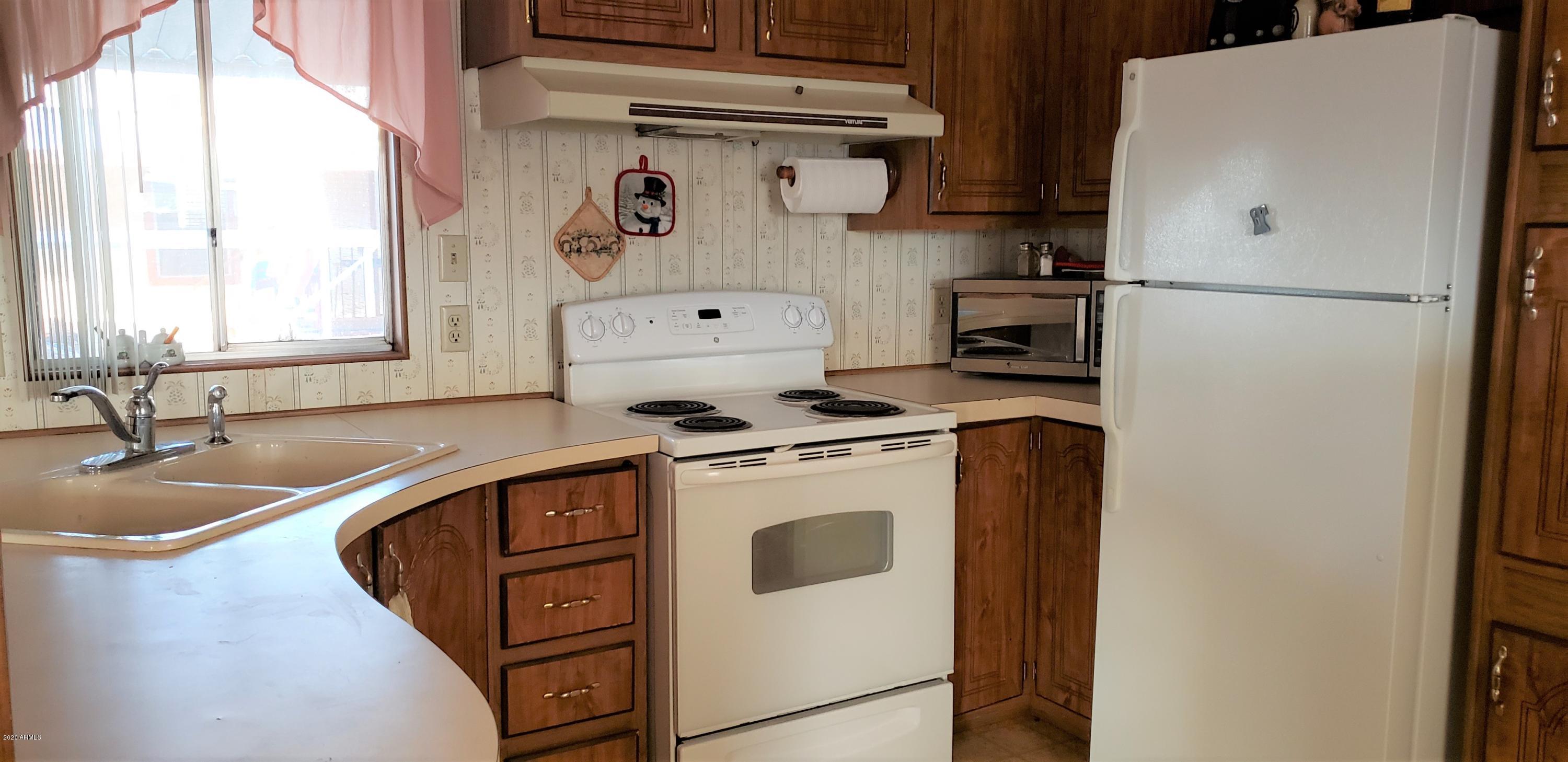 301 South Signal Butte Road, Unit 735 Apache Junction, AZ 85120 - Photo 6 of 27 a kitchen with a refrigerator and a sink