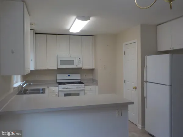 a refrigerator freezer sitting in a kitchen with white cabinets