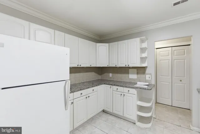a kitchen with white cabinets and white appliances