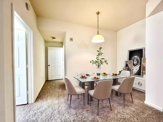a dining room with furniture potted plants and wooden floor