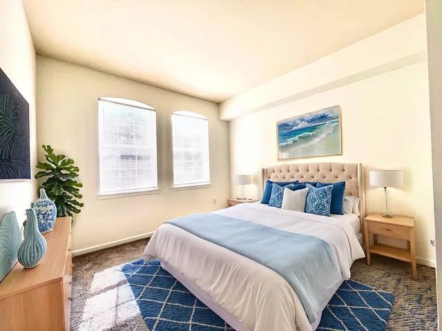 a bedroom with a bed and a potted plant