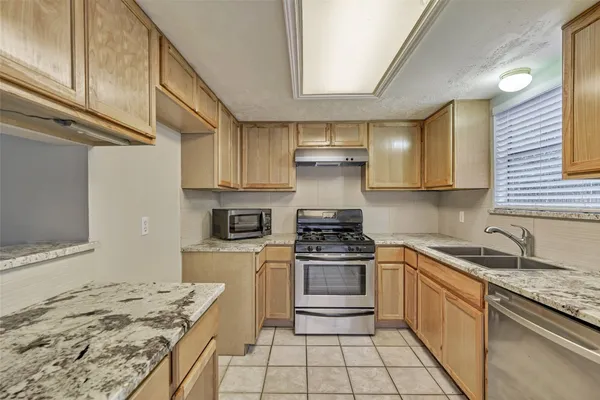 a kitchen with a stove sink and cabinets