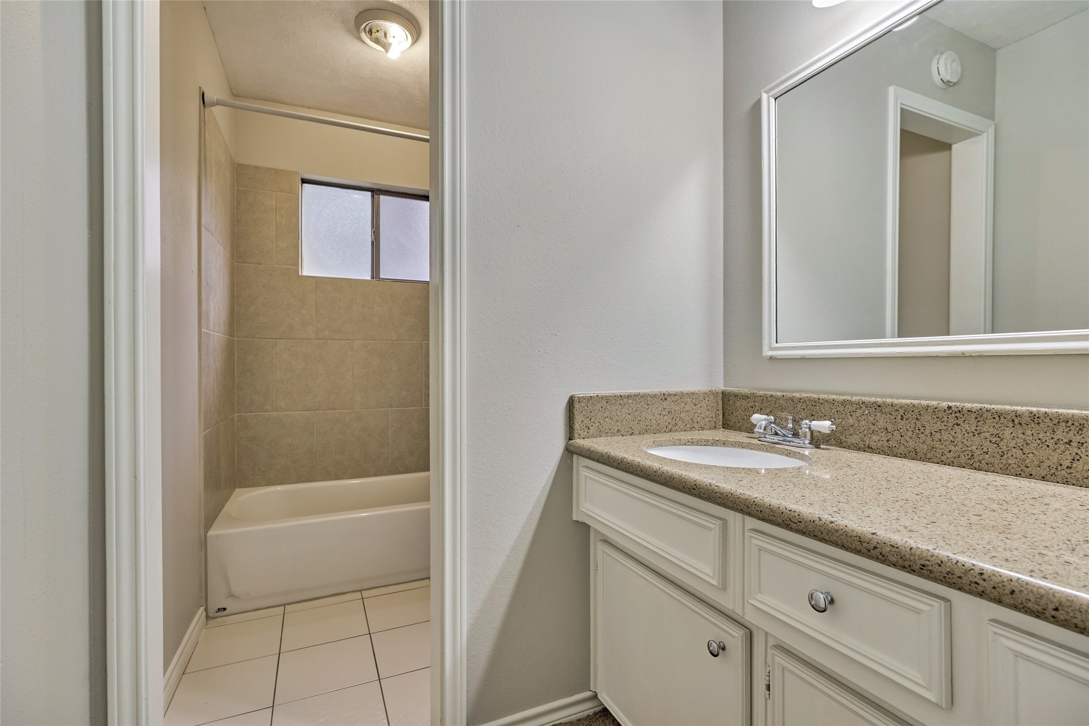3 Field Flower Court Spring, TX 77380 - Photo 31 of 36 a bathroom with a granite countertop sink a mirror and a bathtub