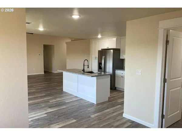 a kitchen with stainless steel appliances kitchen island granite countertop a refrigerator and a sink