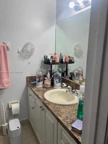 a bathroom with a granite countertop sink a mirror and a toilet