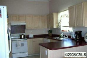 5123 Cheviot Road Charlotte, NC 28269 - Photo 3 of 7 a kitchen with granite countertop a sink a stove and cabinets