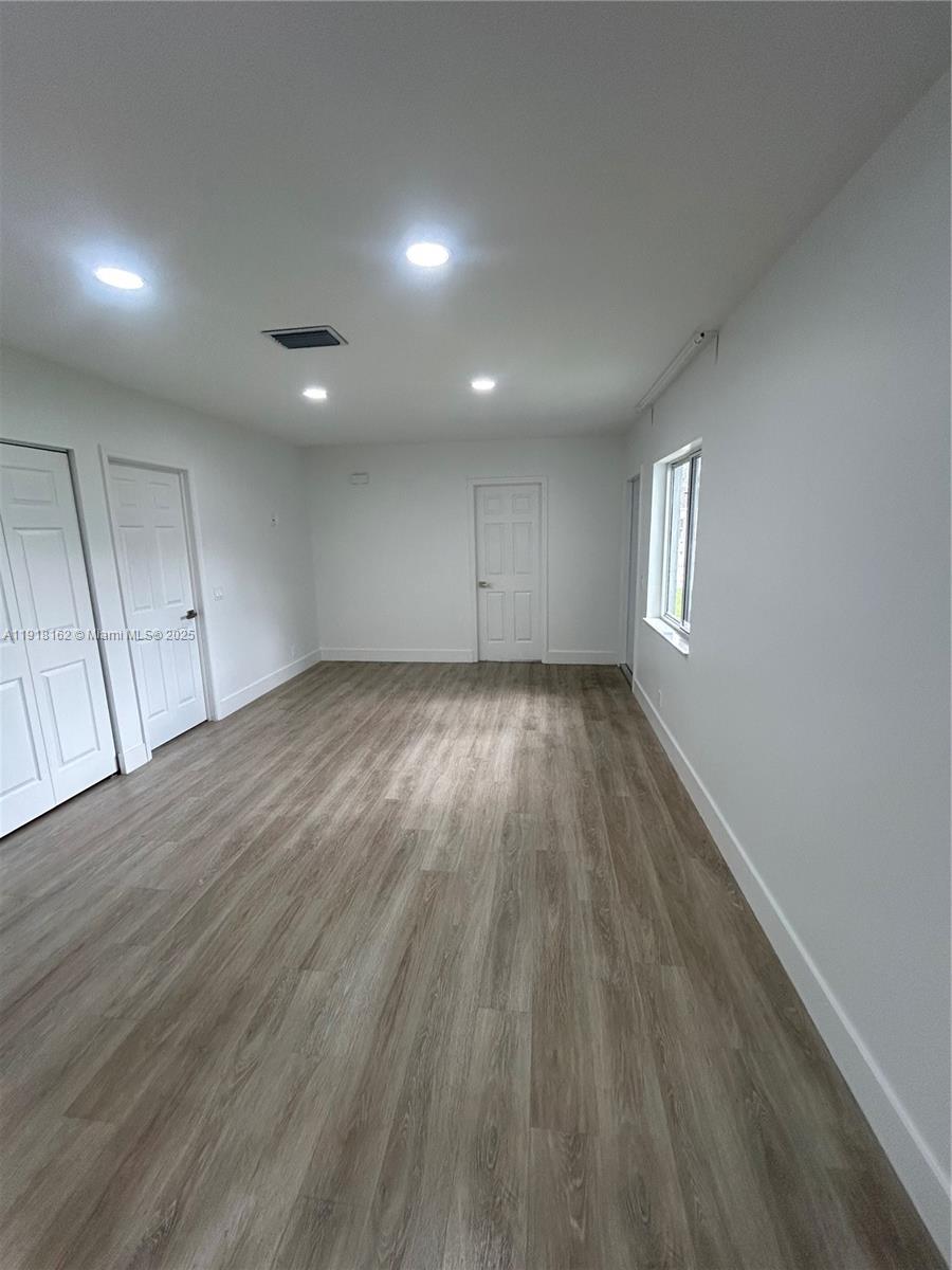 6121 Southwest 48th Court, Unit 3 Davie, FL 33314 - Photo 2 of 14 an empty room with wooden floor and windows