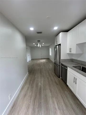 a view of a kitchen with a sink and wooden floor