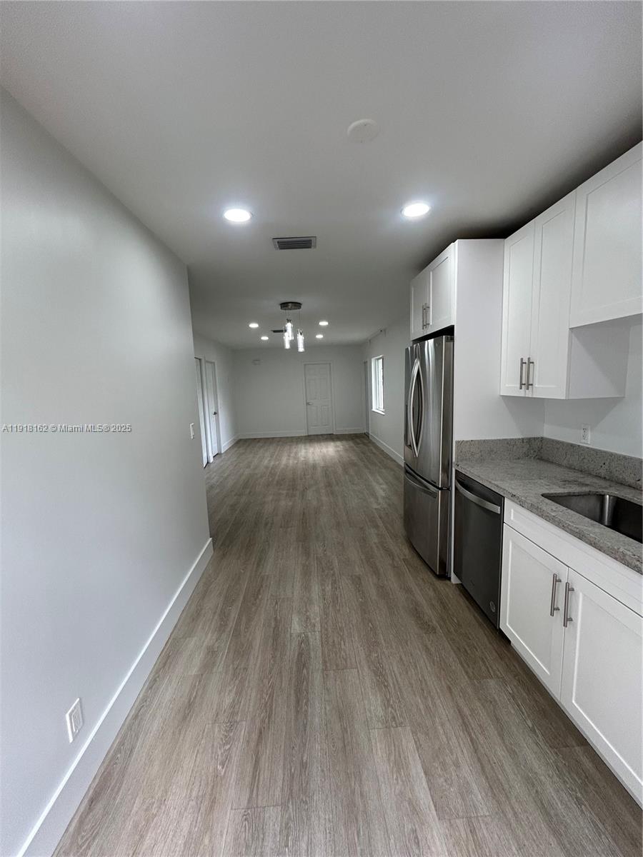 6121 Southwest 48th Court, Unit 3 Davie, FL 33314 - Photo 3 of 14 a view of a kitchen with a sink and wooden floor