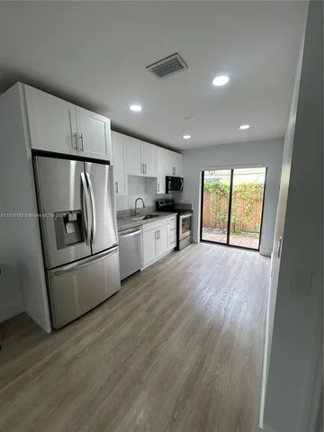 a kitchen with refrigerator a stove top oven a refrigerator and a window