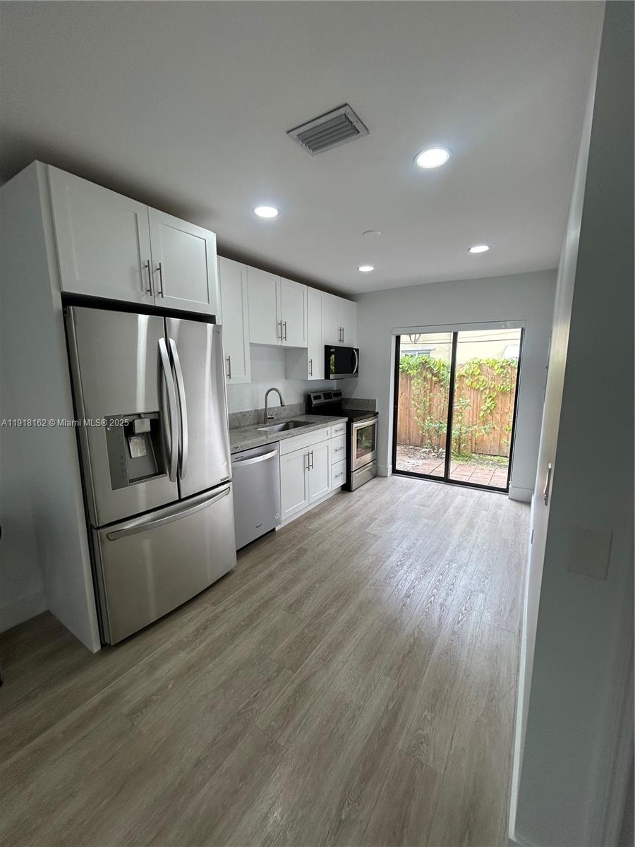 6121 Southwest 48th Court, Unit 3 Davie, FL 33314 - Photo 4 of 14 a kitchen with refrigerator a stove top oven a refrigerator and a window