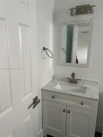 a bathroom with a sink vanity and a mirror