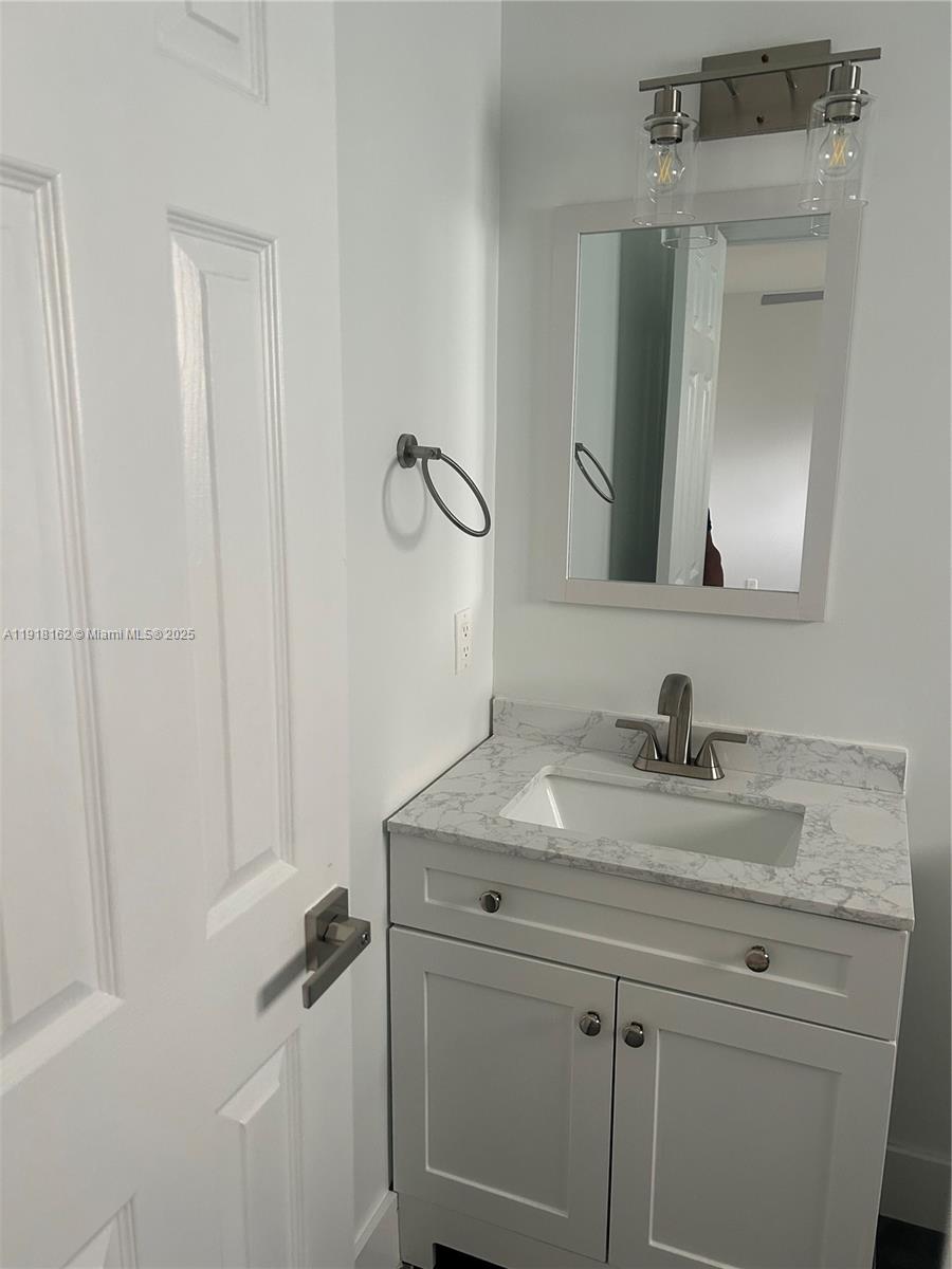 6121 Southwest 48th Court, Unit 3 Davie, FL 33314 - Photo 5 of 14 a bathroom with a sink vanity and a mirror
