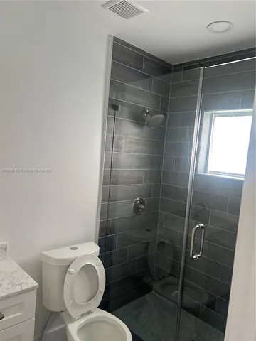 a bathroom with a toilet and a shower