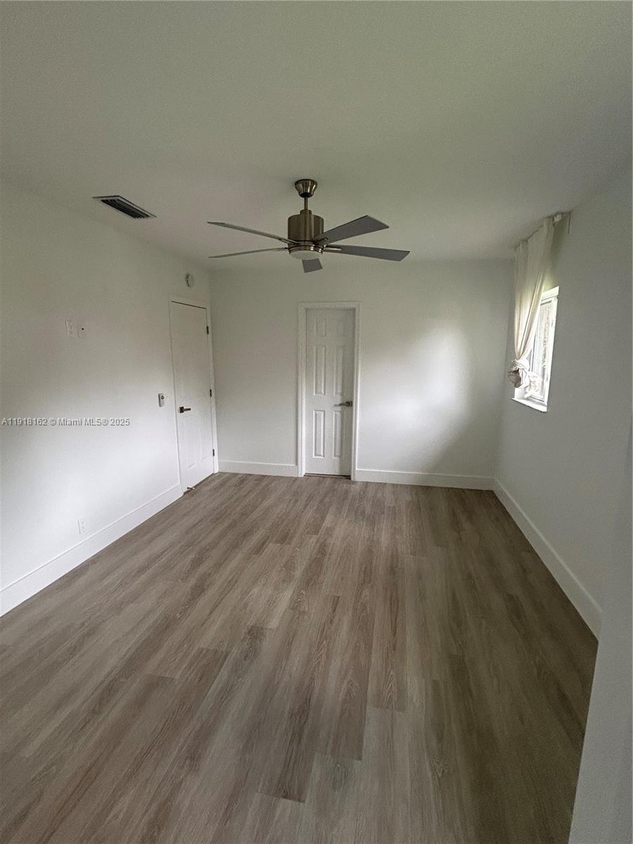 6121 Southwest 48th Court, Unit 3 Davie, FL 33314 - Photo 7 of 14 wooden floor in an empty room with a window