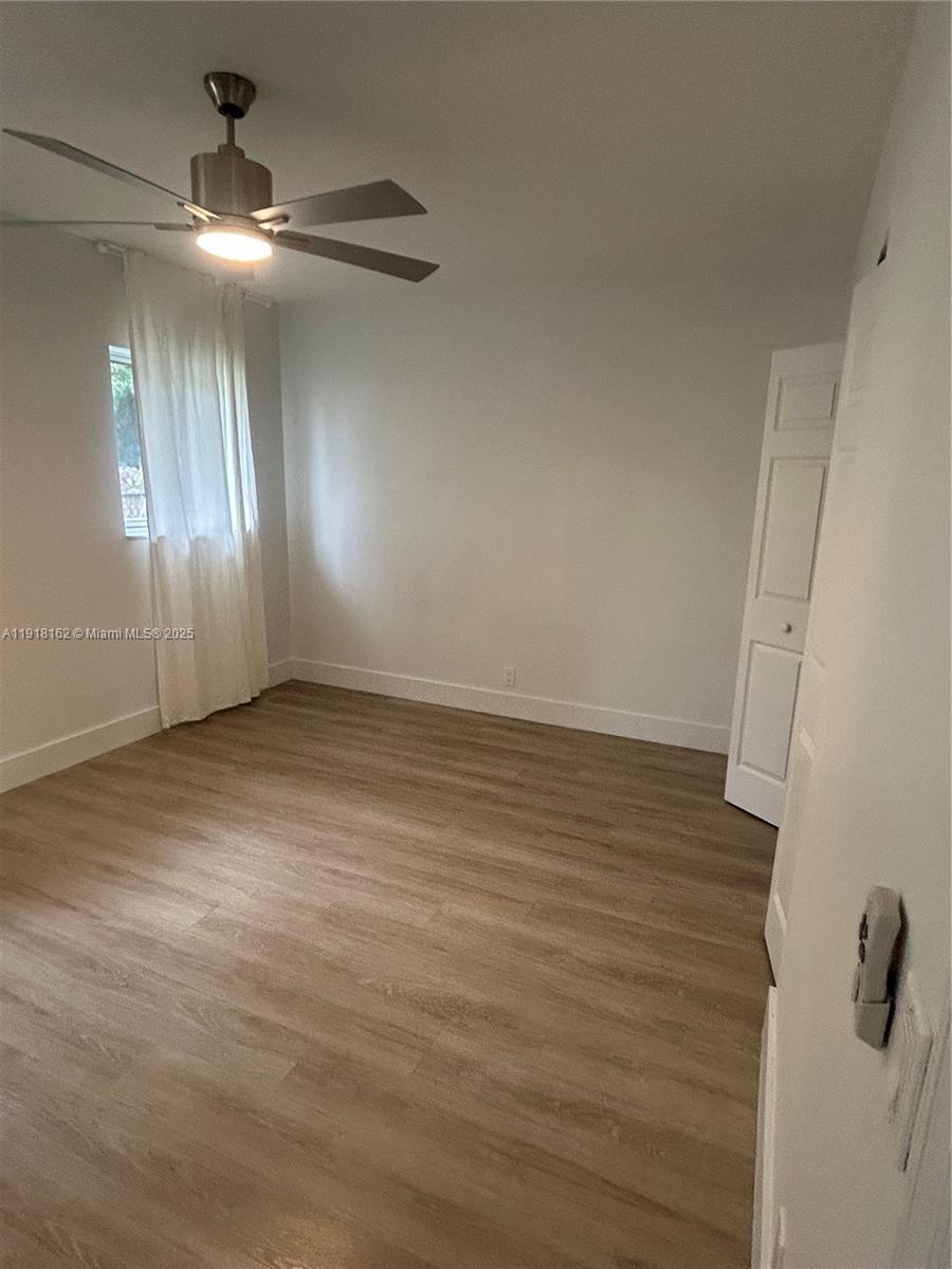 6121 Southwest 48th Court, Unit 3 Davie, FL 33314 - Photo 10 of 14 wooden floor in an empty room with a window