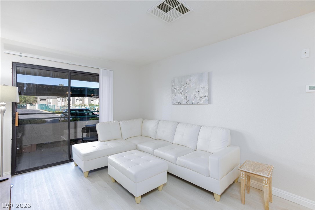 5171 South Lindell Road, Unit 103 Las Vegas, NV 89118 - Photo 6 of 24 Sliding glass doors open to a sun-filled living space featuring light-toned flooring.