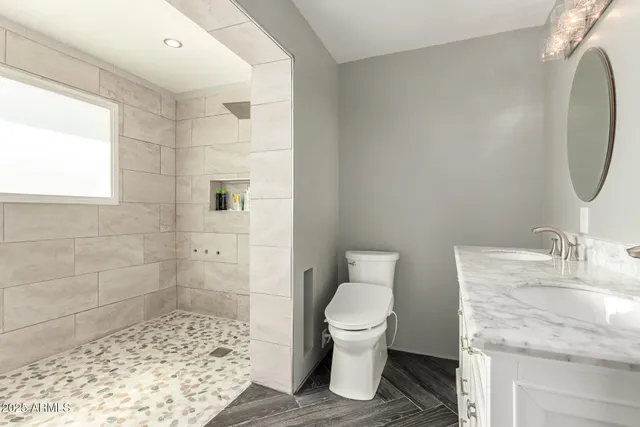 a bathroom with a granite countertop sink toilet and shower