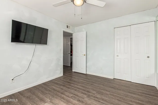 a view of an empty room with wooden floor and a cabinet