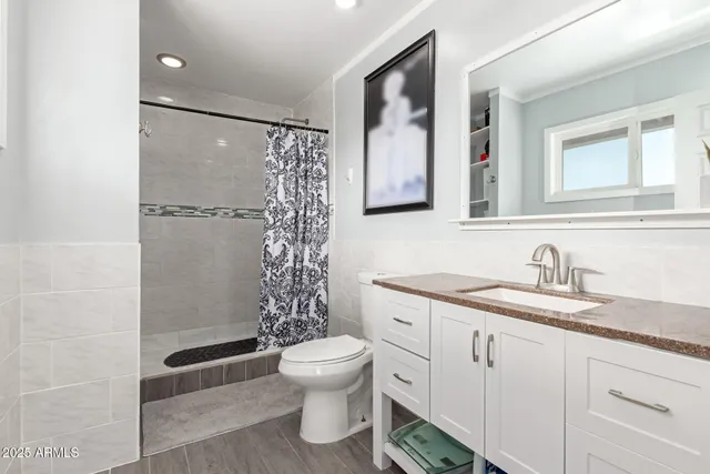 a bathroom with a granite countertop sink toilet and shower