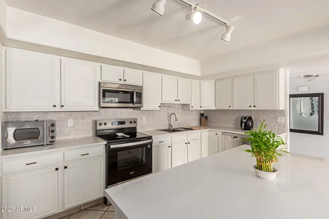 a kitchen with granite countertop white cabinets and white appliances