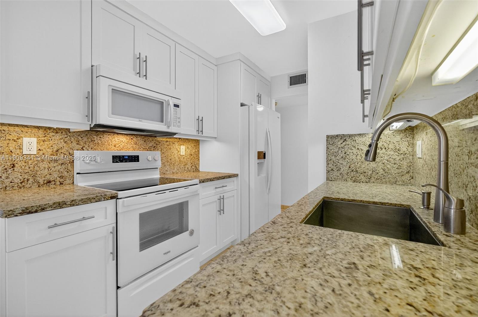 6061 Collins Avenue, Unit 7B Miami Beach, FL 33140 - Photo 22 of 41 a kitchen with stainless steel appliances granite countertop a sink a stove and a refrigerator