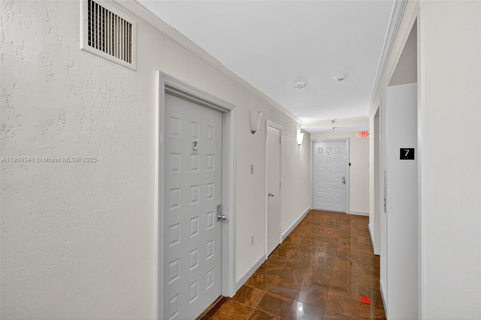 6061 Collins Avenue, Unit 7B Miami Beach, FL 33140 - Photo 30 of 41 a view of a hallway with wooden floor and entryway