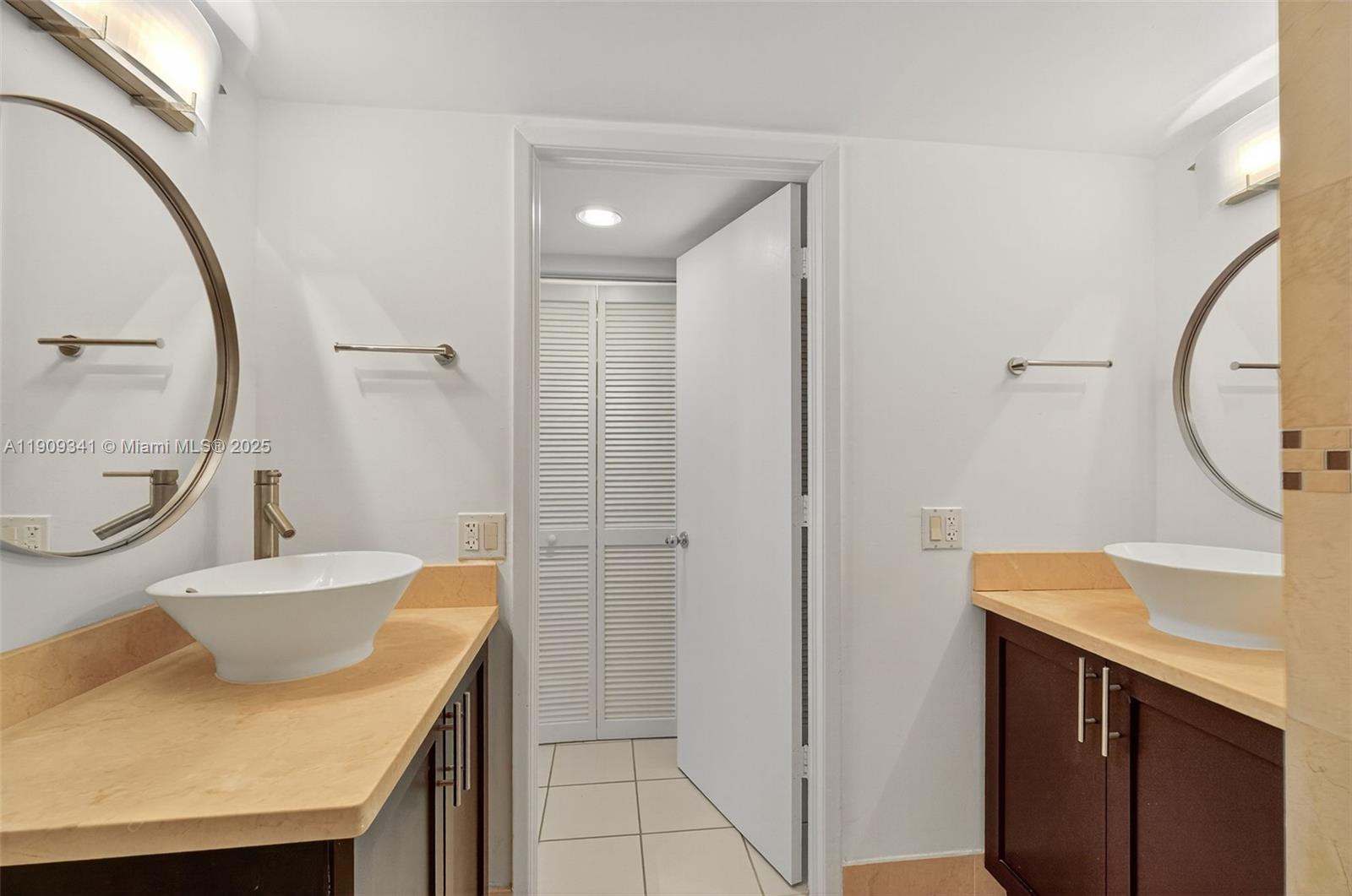 6061 Collins Avenue, Unit 7B Miami Beach, FL 33140 - Photo 37 of 41 a bathroom with a sink a toilet and a mirror