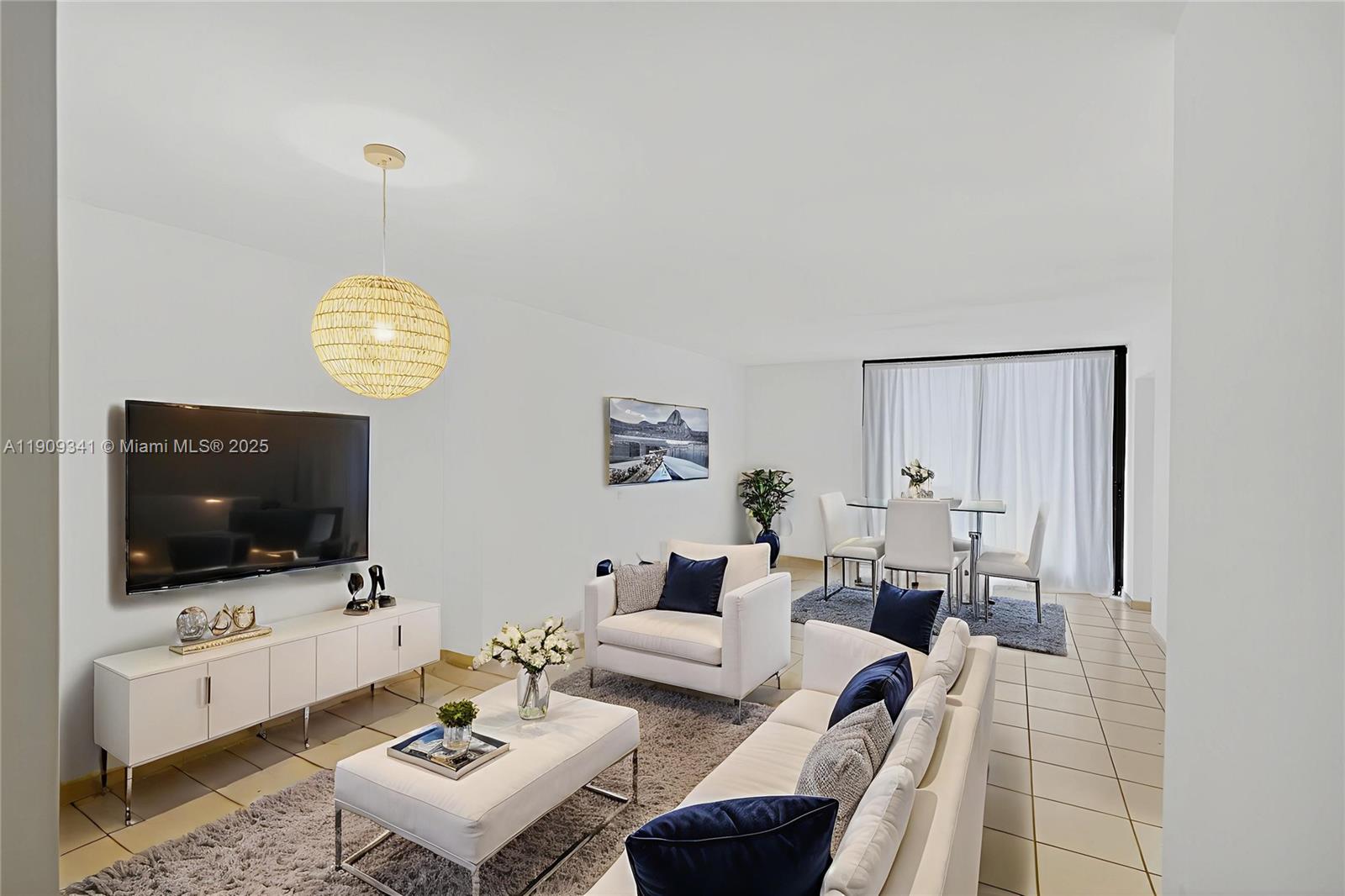 6061 Collins Avenue, Unit 7B Miami Beach, FL 33140 - Photo 5 of 41 a living room with furniture a flat screen tv and a window