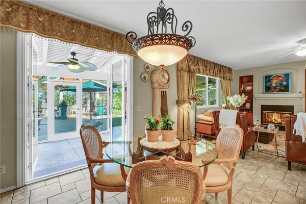 a view of a patio with table and chairs potted plants and a large tree