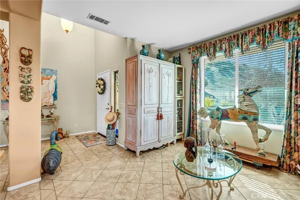 a living room with furniture kitchen view and a chandelier