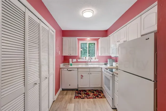 a kitchen with a sink a refrigerator a window and cabinets