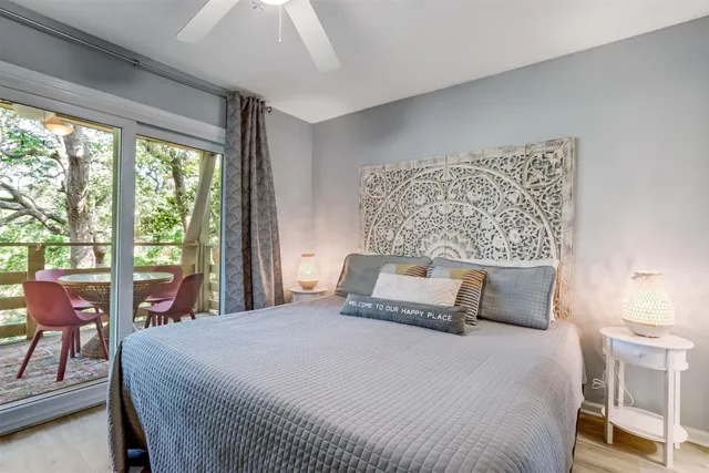 a bedroom with a large bed and wooden floor