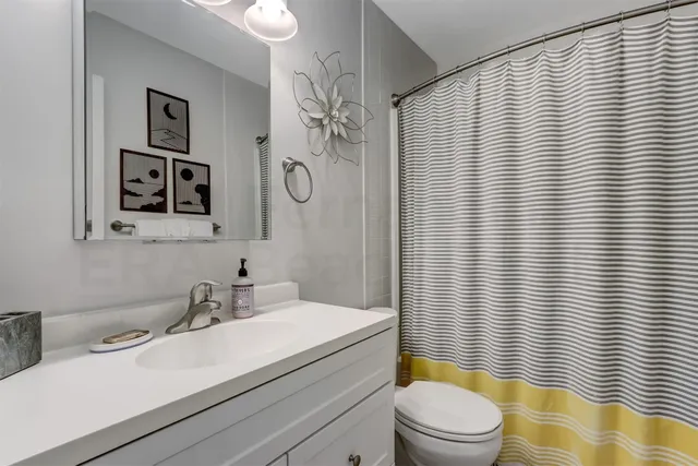a bathroom with a sink a toilet and shower curtain