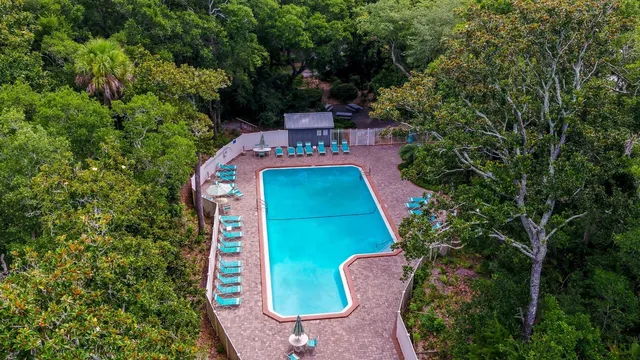 an aerial view of a house with a yard fire pit and outdoor seating