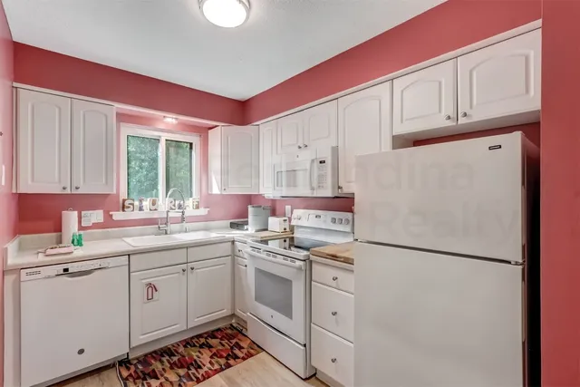 a kitchen with a sink refrigerator and cabinets