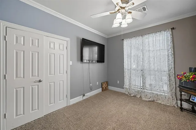 an empty room with windows and ceiling fan