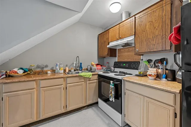 a kitchen with a sink stove and cabinets
