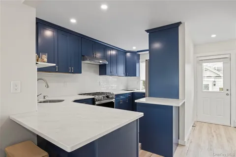 a kitchen with stainless steel appliances a sink a stove a refrigerator and cabinets