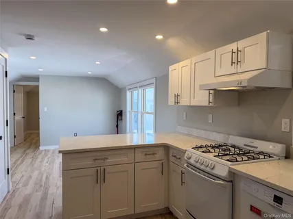 a kitchen with white cabinets and appliances