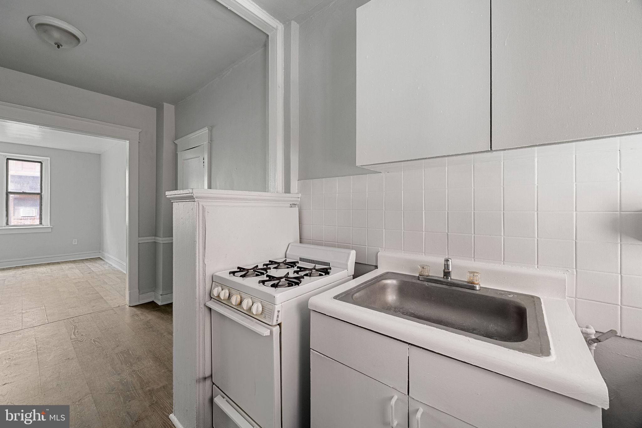 7250 Chestnut Street, Unit E101 Upper Darby, PA 19082 - Photo 12 of 18 a kitchen that has a sink cabinets and appliances