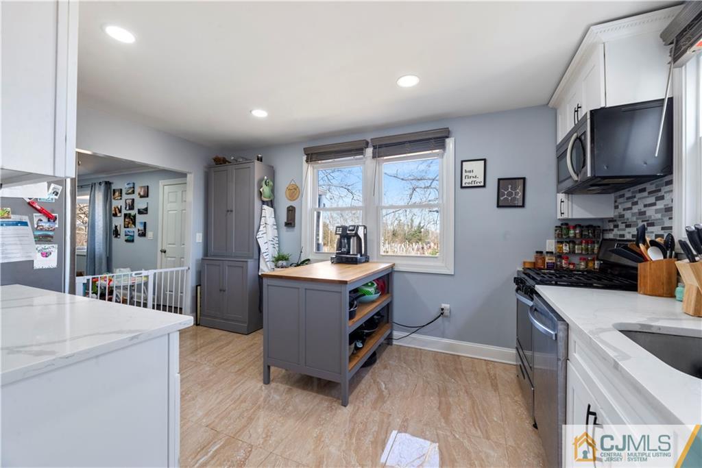 57 Dunhams Corner Road East Brunswick, NJ 08816 - Photo 12 of 31 a kitchen with stainless steel appliances granite countertop a sink stove and refrigerator