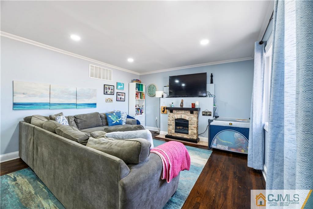 57 Dunhams Corner Road East Brunswick, NJ 08816 - Photo 15 of 31 a living room with furniture a fireplace and a flat screen tv