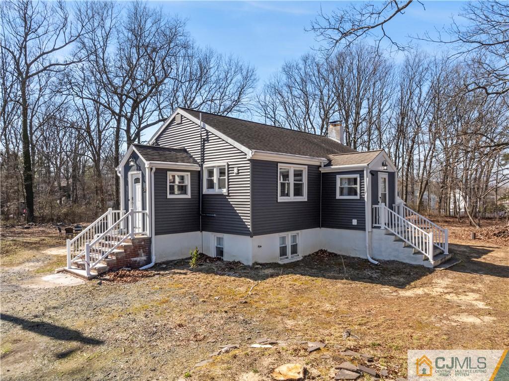 57 Dunhams Corner Road East Brunswick, NJ 08816 - Photo 3 of 31 a front view of a house with a yard covered in snow