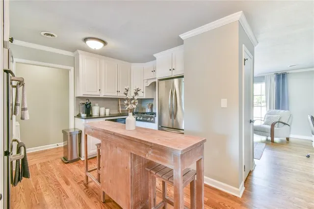 a kitchen with stainless steel appliances granite countertop a sink and wooden floors